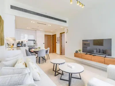 a living room with a white couch and a tv at TRPS - Binghatti Lavender, JVC - Premium 1BR Retreat, Fully Furnished in Dubai