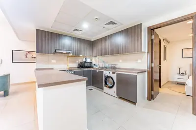a kitchen with a washer and dryer in a house at Few Metres Walk to Metro, Minutes Drive from Ibn Battuta Mall, Victoria Residency, Al Furjan by Deluxe Holiday Homes in Dubai