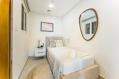 a white bedroom with a bed and a mirror at Few Metres Walk to Metro, Minutes Drive from Ibn Battuta Mall, Victoria Residency, Al Furjan by Deluxe Holiday Homes in Dubai