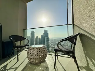 a room with two chairs and a table on a balcony at Homelike Charm High-End Furnished and Luxurious in Dubai