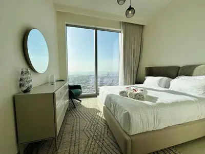 a hotel room with a bed and a large window at Homelike Charm High-End Furnished and Luxurious in Dubai
