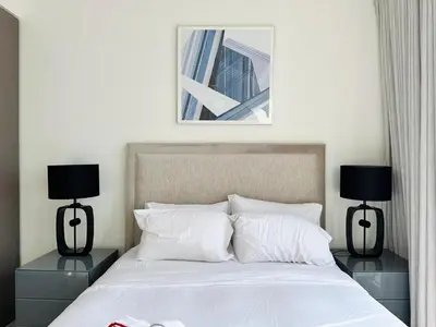 a bedroom with a bed with two nightstands and two lamps at Homelike Charm High-End Furnished and Luxurious in Dubai