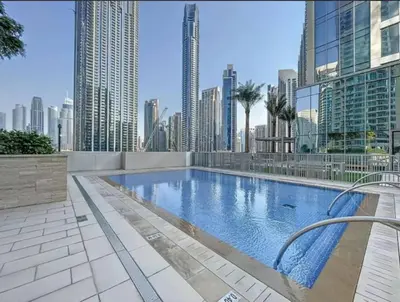 a large swimming pool in a city with tall buildings at Homelike Charm High-End Furnished and Luxurious in Dubai