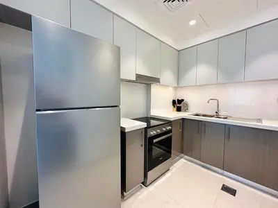 a kitchen with a stainless steel refrigerator and a sink at Homelike Charm High-End Furnished and Luxurious in Dubai
