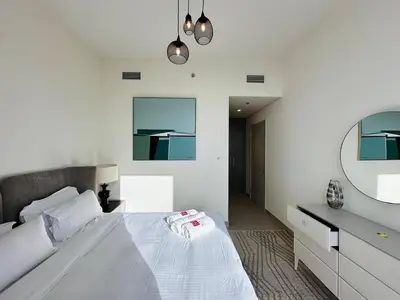 a bedroom with a white bed and a mirror at Homelike Charm High-End Furnished and Luxurious in Dubai