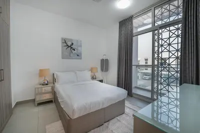 a bedroom with a bed and a large window at EasyGo-Elavated Urban Living Stylish 3Bedroom townhouse in Dubai