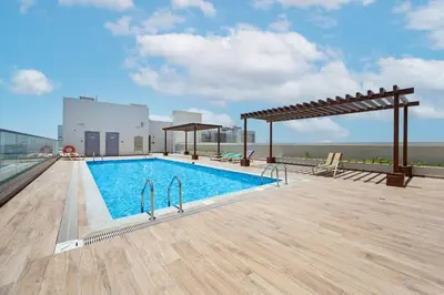 a swimming pool on the roof of a building at Luxury Studio Apartment in Dubai