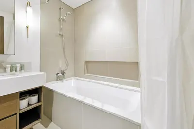 a white bathroom with a tub and a sink at Appealing 2BR at 17 Icon Bay, Dubai Creek Harbour in Dubai
