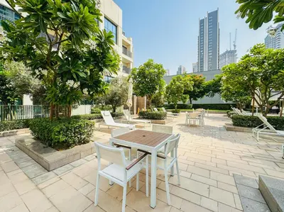 a patio with a table and chairs and trees at Appealing 1BR at 17 Icon Bay, Dubai Creek Harbour in Dubai