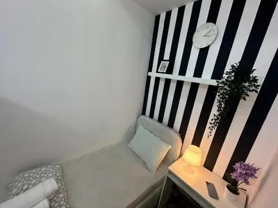 a small room with a bench with a clock on a wall at Simple Stay Partition Room In Barsha heights Tecom in Dubai