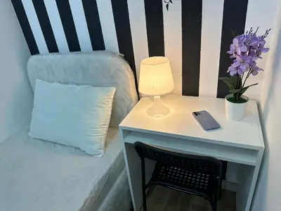 a table with a lamp and a bed with a pillow at Simple Stay Partition Room In Barsha heights Tecom in Dubai