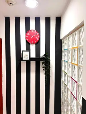 a black and white striped wall with a clock on a wall at Small Partition Room Barsha Heights Tecom in Dubai