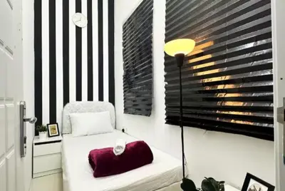 a bedroom with a bed with a lamp and a window at Beautiful Partition Room in Al Barsha 1 in Dubai