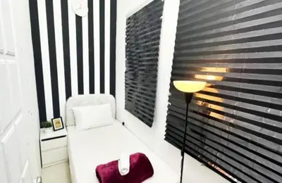 a white chair in a room with a window at Beautiful Partition Room in Al Barsha 1 in Dubai