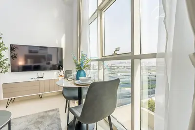 a dining room with a table and chairs and a large window at Studio Near Dubai Water Canal and Bus Station, Conveniently Close to Downtown, The Scala Tower, Business Bay by Deluxe Holiday Homes in Dubai