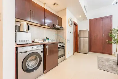 a kitchen with a washing machine and a washer at Studio Near Dubai Water Canal and Bus Station, Conveniently Close to Downtown, The Scala Tower, Business Bay by Deluxe Holiday Homes in Dubai
