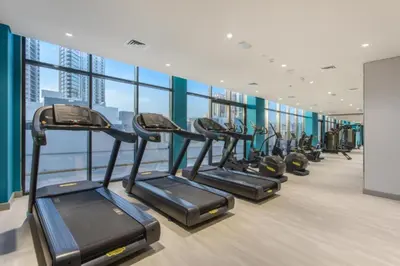 a gym with a row of treadmills in a building at Modern Studio Near Downtown Dubai, Few Mins Walk to Hartland Greens Park, Azizi Riviera 43, Al Merkadh by Deluxe Holiday Homes in Dubai
