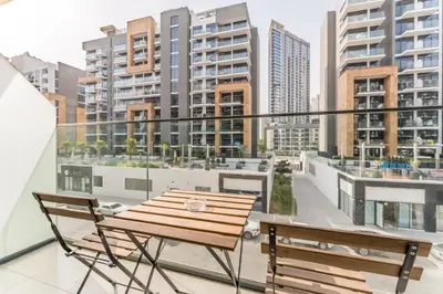 a balcony with a table and chairs and buildings at Modern Studio Near Downtown Dubai, Few Mins Walk to Hartland Greens Park, Azizi Riviera 43, Al Merkadh by Deluxe Holiday Homes in Dubai