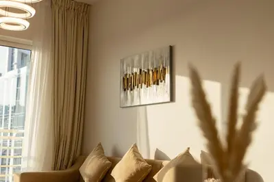 a living room with a couch and a painting on the wall at Luxury 2BHK in Jumeirah Lakes Towers Icon 3502 in Dubai