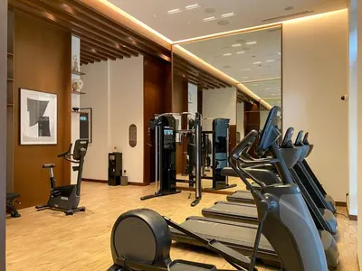 a gym with a row of treadmills and ellipticals at FIRST CLASS 2BR Creek Beach Relax in Style in Dubai