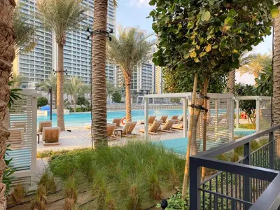 a view of a resort with palm trees and a pool at FIRST CLASS 2BR Creek Beach Relax in Style in Dubai
