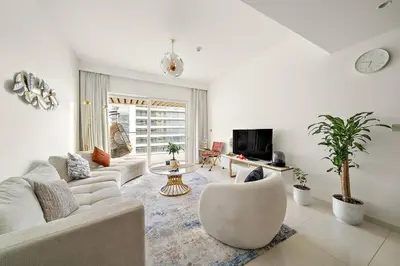 a living room with a couch and a tv at Beachfront 2BR Grand Bleu Luxe Near Dubai Palm & Marina Hotspots in Dubai