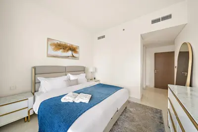 a bedroom with a bed with two towels on it at Beachfront 2BR Grand Bleu Luxe Near Dubai Palm & Marina Hotspots in Dubai