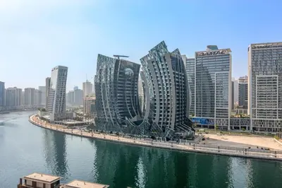 a city with tall buildings next to a river at Apartment with Burj Khalifa, Canal View with Big Balcony in Dubai