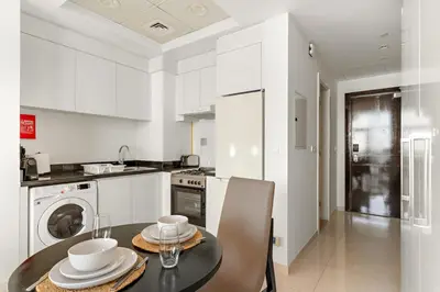a kitchen with a table with dishes on it at Modern JVC Studio with Pool Gym and Easy Access to Attractions in Dubai