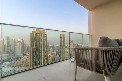 a chair in a room with a view of a city at FIRST CLASS 4BR Luxe Downtown Escape in Dubai