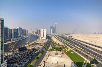 an aerial view of a city with tall buildings at Convertible 1BR with Canal and Skyline View by BMS in Dubai