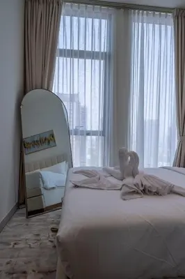 a bedroom with a bed with a stuffed animal on it at Homes & Beyond l Serene 1BR Retreat in JVC in Dubai