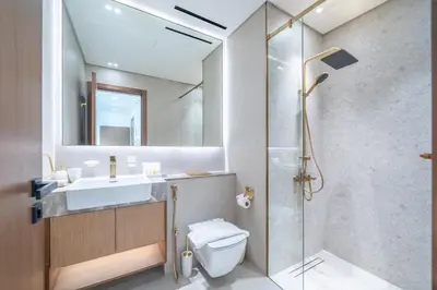 a bathroom with a shower and a toilet and a sink at Homes & Beyond l Serene 1BR Retreat in JVC in Dubai