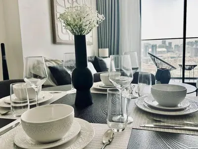 a dining room table with a vase of flowers and wine glasses at Crisp And Curated 1br With Pool, Gym And Parking! in Dubai