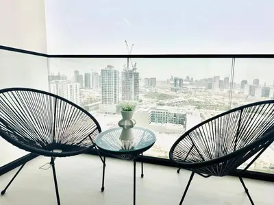 two chairs and a glass table in front of a window at Crisp And Curated 1br With Pool, Gym And Parking! in Dubai