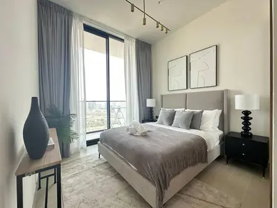 a bedroom with a large bed and a large window at Crisp And Curated 1br With Pool, Gym And Parking! in Dubai