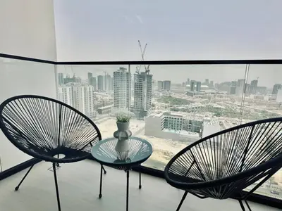 two chairs and a glass table in front of a window at Crisp And Curated 1br With Pool, Gym And Parking! in Dubai