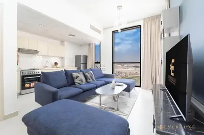 a living room with a blue couch and a table at Stylish 1br In Midtown Impz Soft Modern Vibes in Dubai