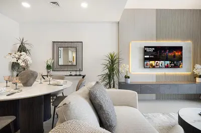 a living room with a table and a tv at Luxury 2,5BR Burj Khalifa Views with Pool and Gym Access Near Dubai Mall in Dubai