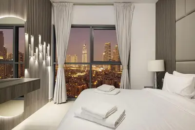 a bedroom with a white bed with a city view at Luxury 2,5BR Burj Khalifa Views with Pool and Gym Access Near Dubai Mall in Dubai