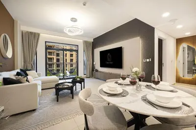a living room with a table and chairs and a couch at Elegant Stay with Pool & Gym Near Iconic Landmarks in Dubai