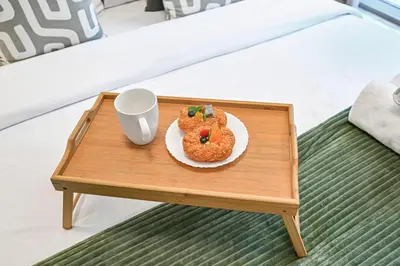 a table with a plate of donuts and a cup on it at Modern Studio Steps from Iconic Dubai Mall & World-Class Amenities in Dubai
