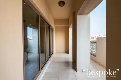 a corridor of a building with a view of a balcony at Bespoke Holiday Homes - Spacious 2BR Luxury Apartment with Stunning Palm Views, Balqis in Dubai
