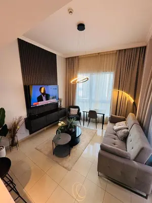 a living room with a couch and a flat screen tv at Bay Central Sea and Canal View, Dubai Marina in Dubai