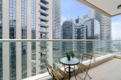 a balcony with a table and chairs and tall buildings at Neat and Cozy 2BR plus Kids Room - 7min to Dubai Mall in Dubai
