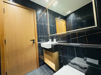 a bathroom with a sink and a wooden door at Private Pool II Spacious II Brand New in Dubai