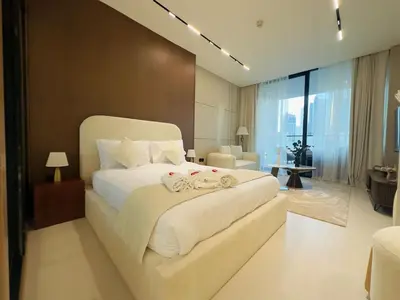 a bedroom with a large white bed with two dolls on it at Brand New with Private Jacuzzi in Dubai