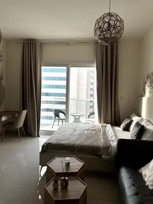a bedroom with a bed and a couch and a large window at Best Canal View Studio in AG Tower Business Bay in Sabkhah