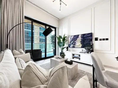 a living room with white furniture and a large window at 1-Bedroom Apartment in Downtown with Pool View in Dubai
