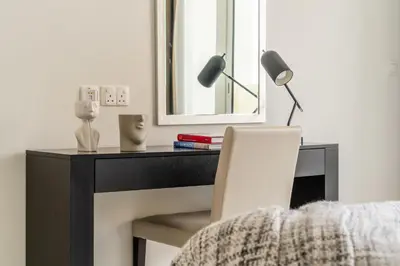 a desk with a mirror and a lamp and a chair at The Smart Concierge - Damac 108 in Dubai